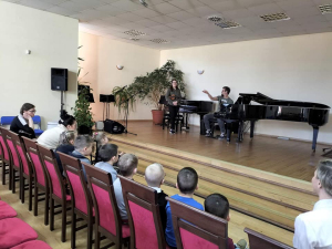 na zdjęciu: przy fortepianie nauczyciel Piotr
 Błoch, obok nauczycielka Joanna Koralewska,
 na widowni przedszkolaki z Bieganowa